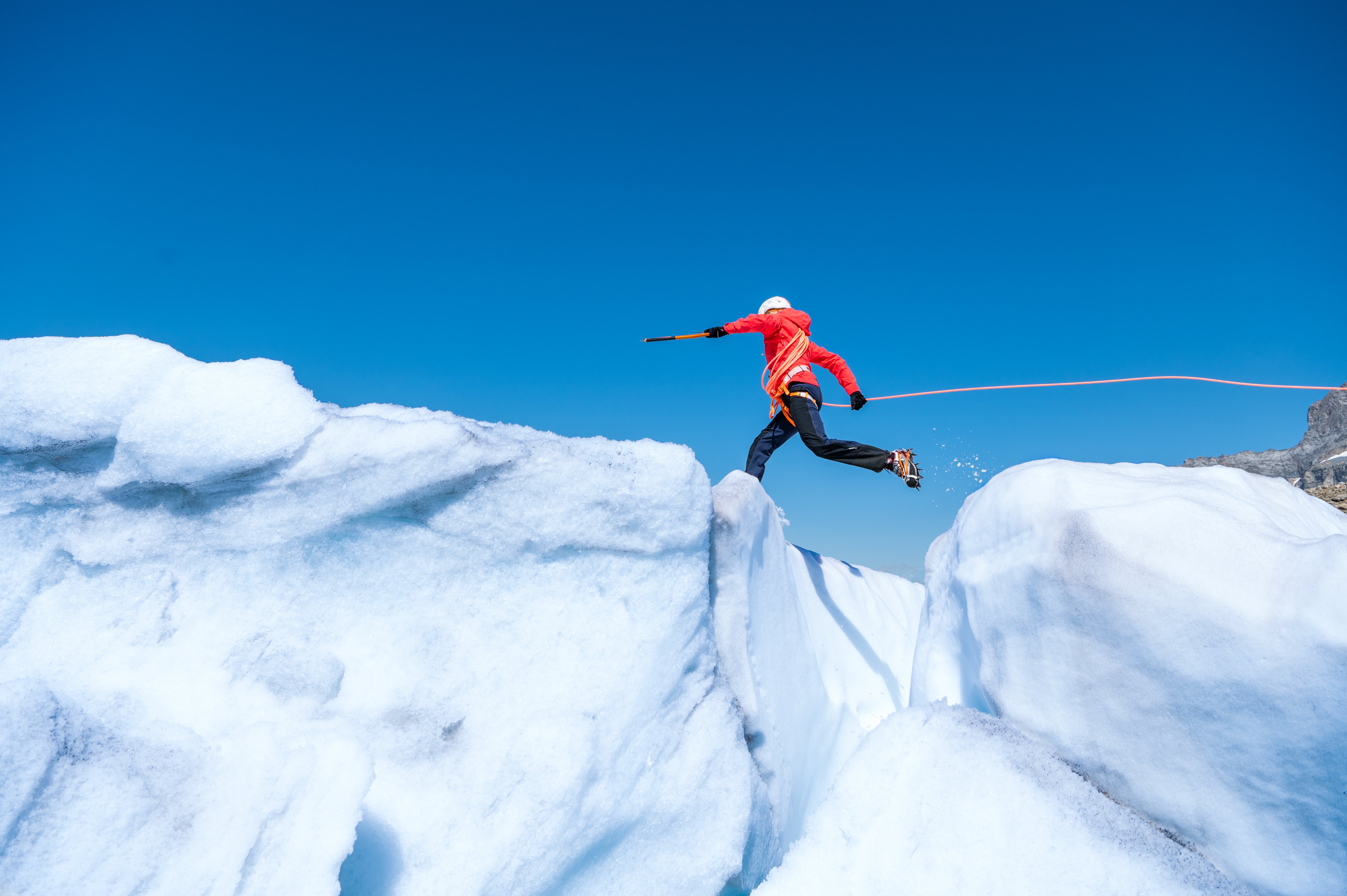 Bergsteiger springt über Gletscherspalte